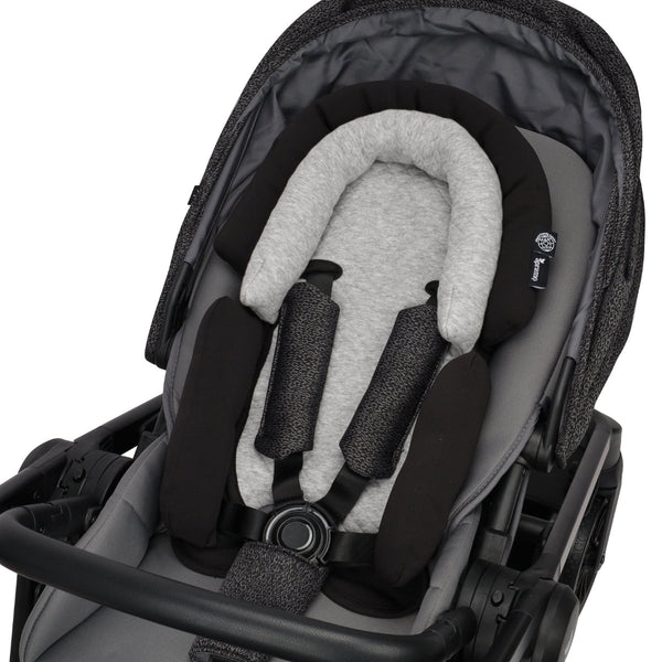 newborn and infant head support in black and grey stroller on white background