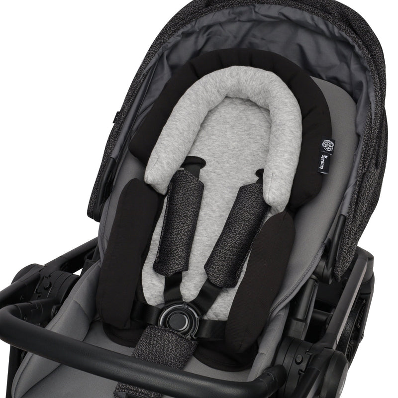 newborn and infant head support in black and grey stroller on white background