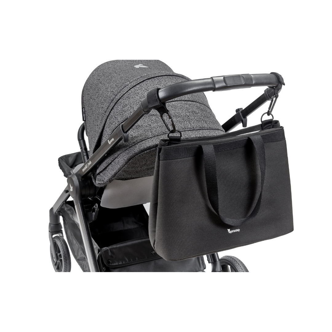 Balck baby changing pram stroller bag attached to stroller pram using stroller hooks on plain white background. Black baby pram changing bag made from 100% recycled sustainable sourced fabrics
