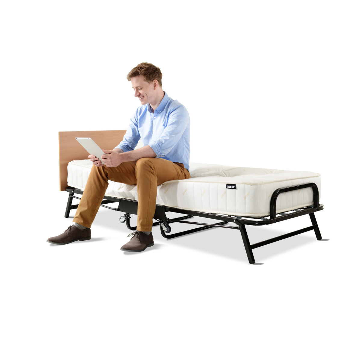 man holding tablet sitting on a Jay-Be Crown Premier Folding Single Bed with Deep Sprung Mattress