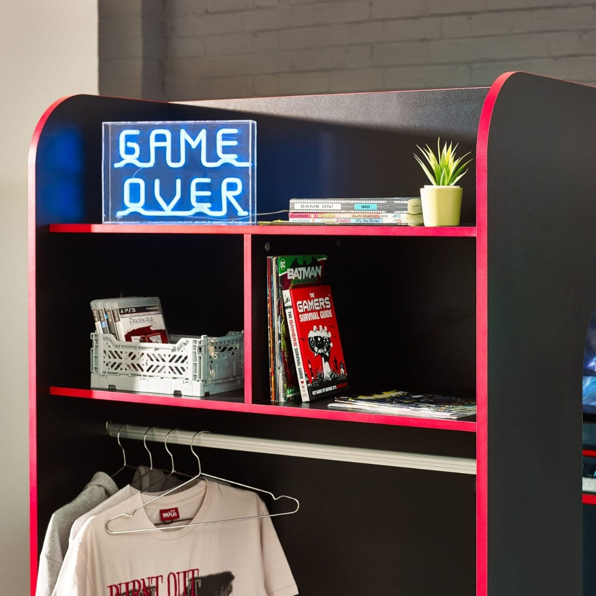 Shelving unit and clothes rail on black and red gaming bed in teens bedroom