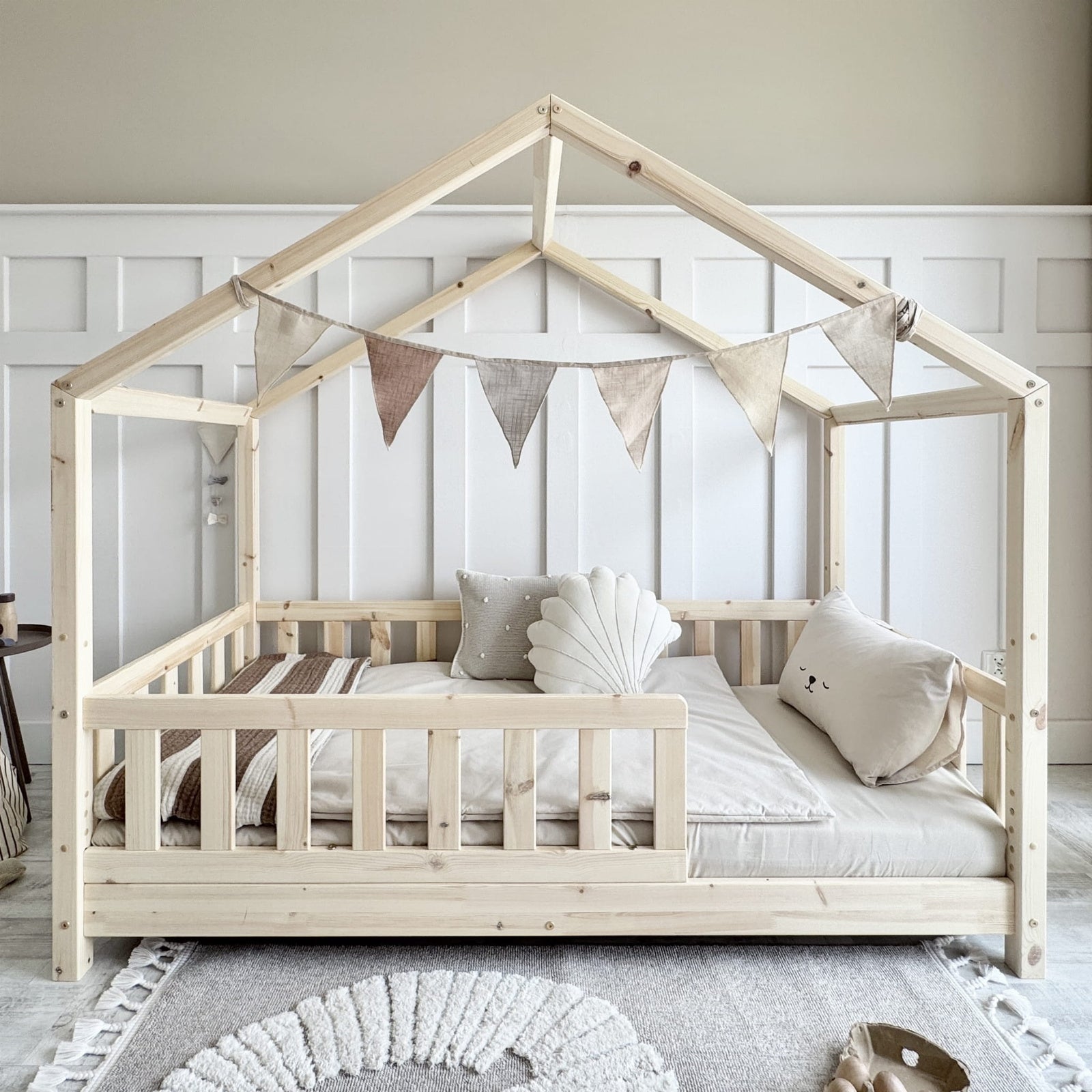 luletto gabby Wooden house-shaped kids bed with bed guard in a european bedroom setting.