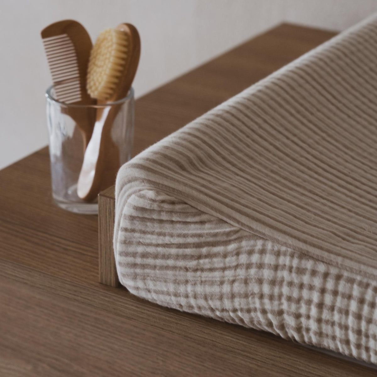 close up of soft cotton fabric on Quax Muslin removable Changing Pad Cover stripes on baby changing  table