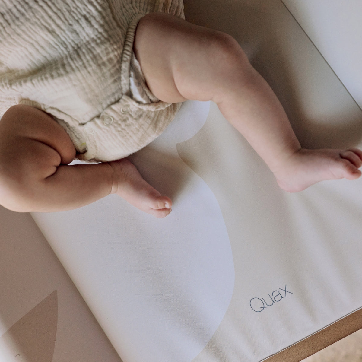 baby laying on a Quax Dove of Peace wedge changing mat 70x50cm with raised sides