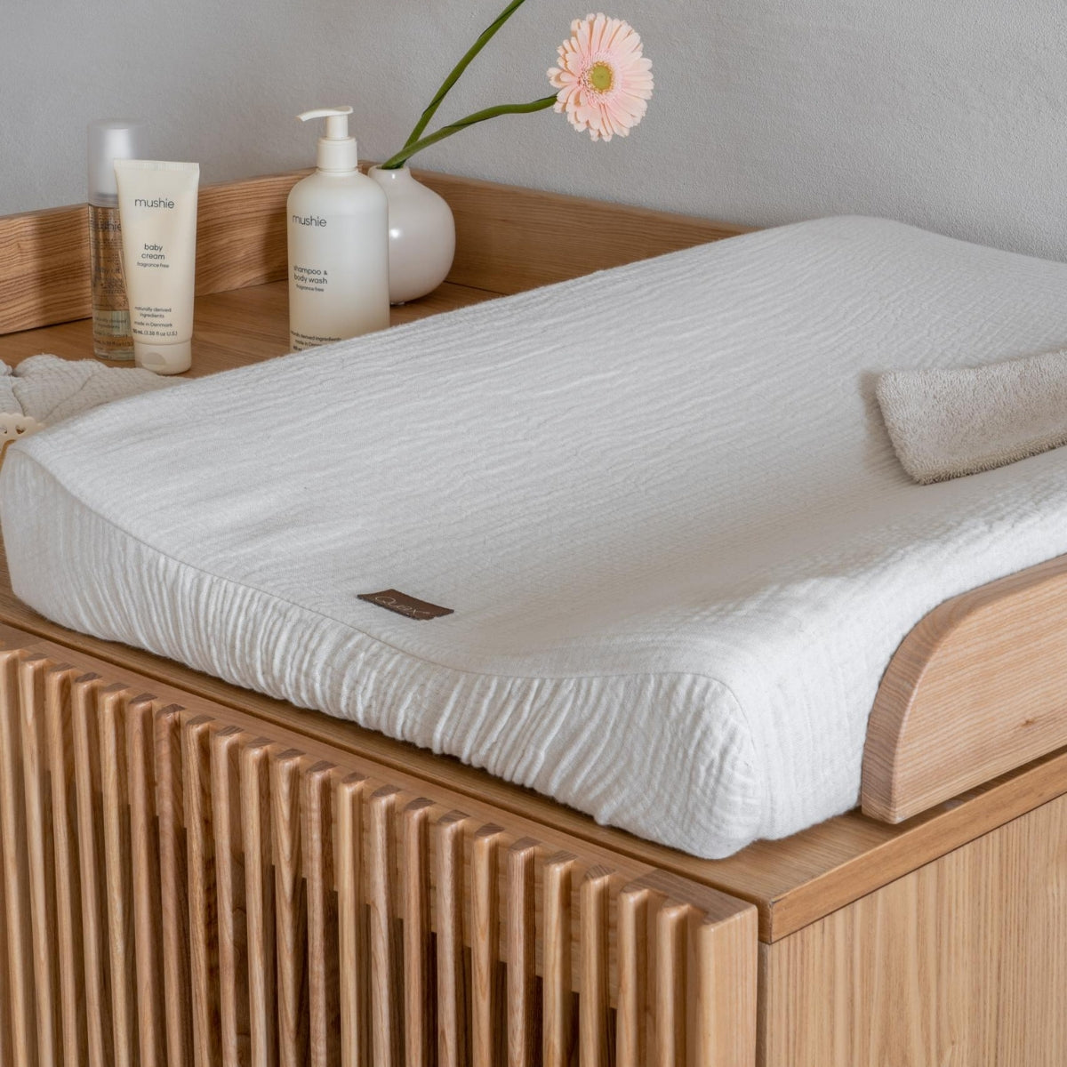 close up of baby changing pad and baby changing essentials on Quax Hai No Ki Natural Ash dresser in Japandi inspired nursery