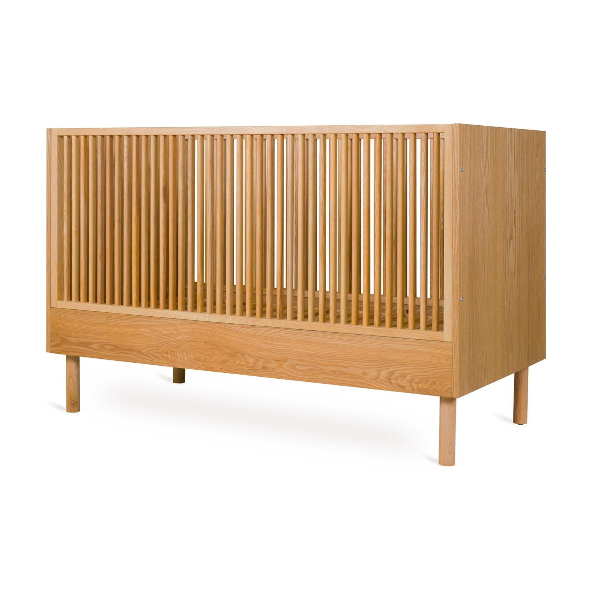 angled view showing solid end panel on Quax Hai No Ki 140 x 70cm convertible cot bed in Natural Ash on white background