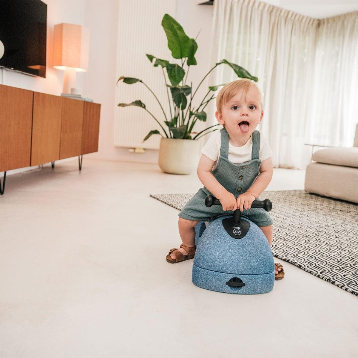 toddler sat on Scoot and Ride My First 3 in 1 Baby Walker in living room