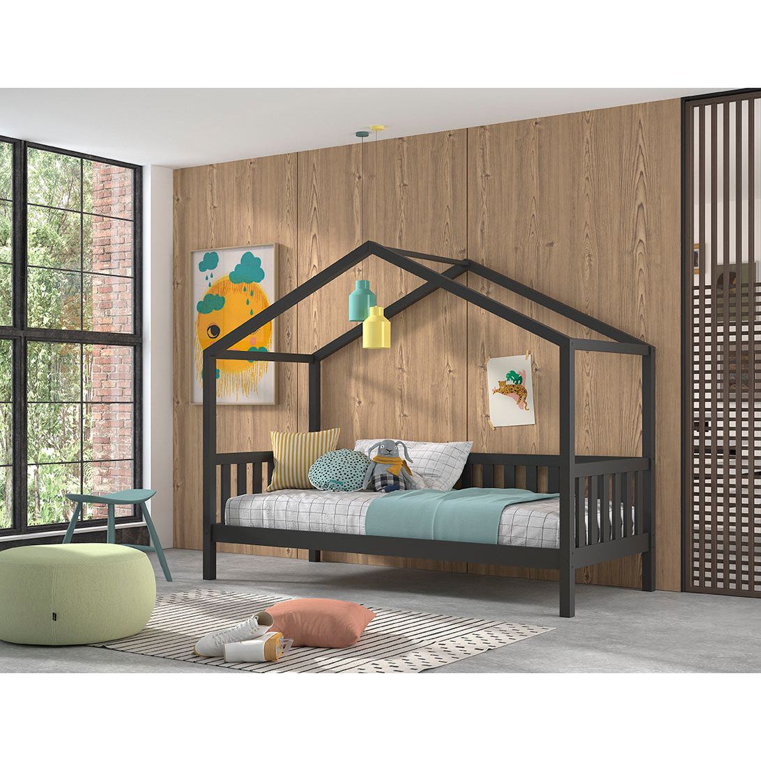 A single house bed frame in anthracite color, made from solid pine with a slatted design, placed in a room with a wooden wall and colorful wall art.