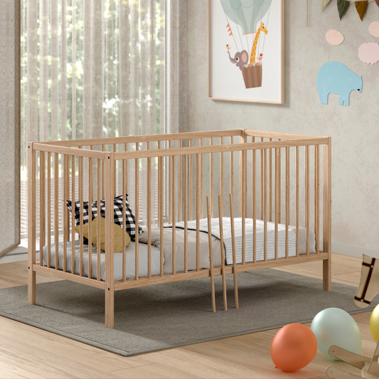 Modern natural coloured wooden 140x70cm cot bed in a modern nursery baby bedroom. FSC certified European beech wooden baby cot. Modern design sturdy looking well built baby cot bed 