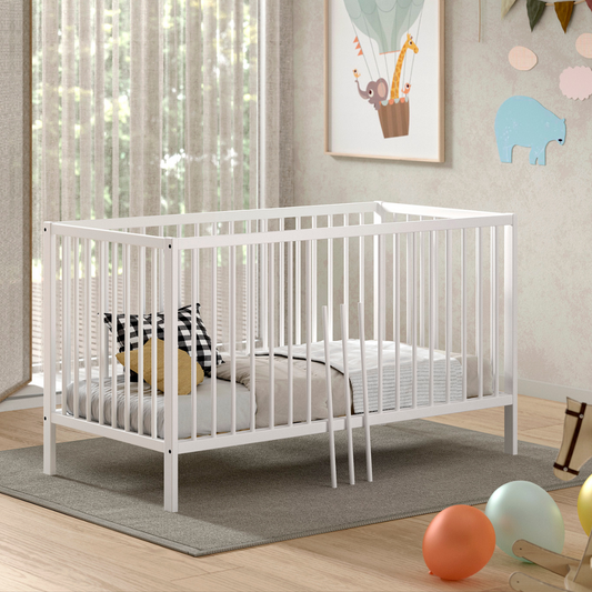 Modern white coloured wooden 140x70cm cot bed in a modern nursery baby bedroom. FSC certified European beech wooden baby cot. Modern design sturdy looking well built white IKEA Scandi style baby cot bed 