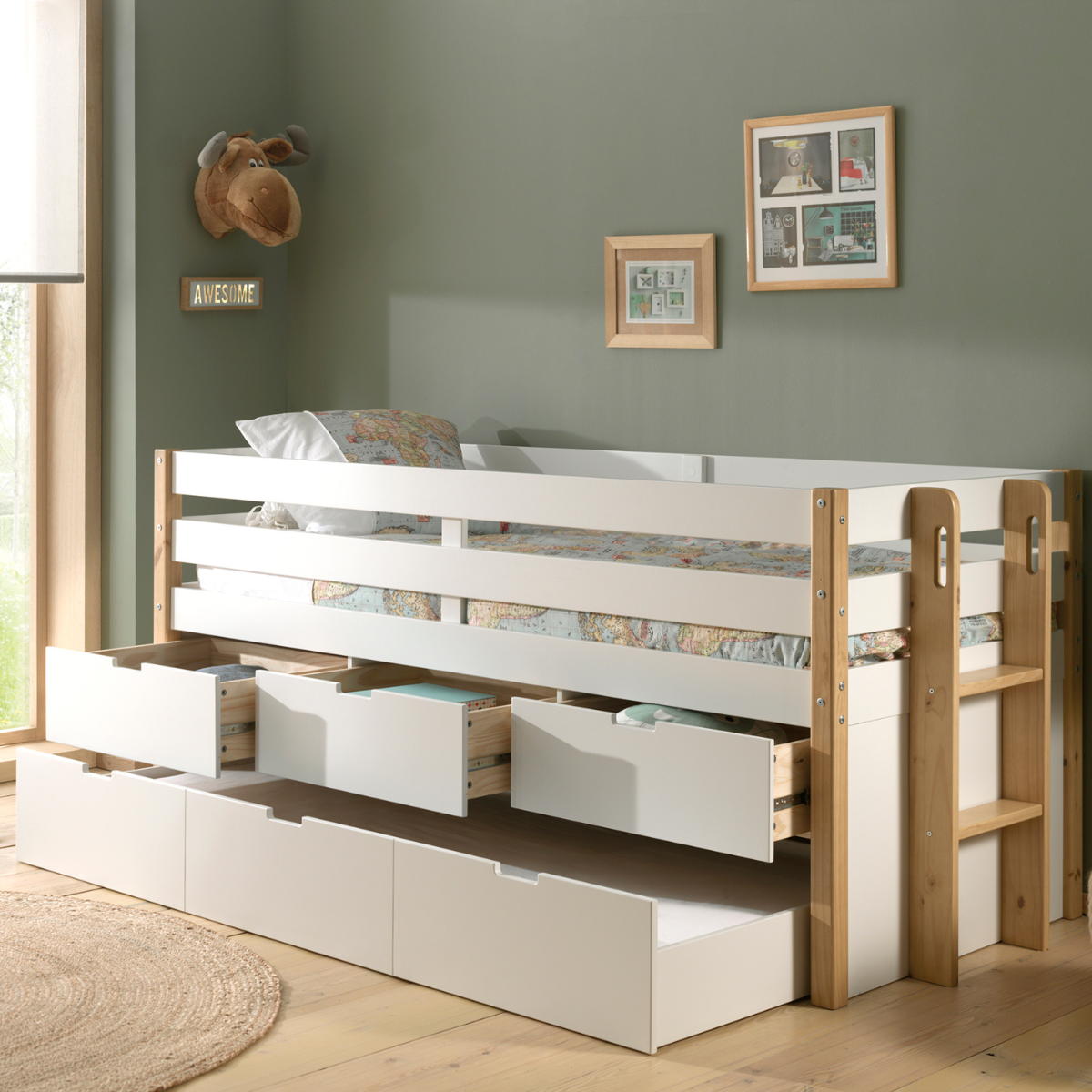 White and wooden childrens cabin bed with multiple open underbed storage drawers in a room with green walls and framed picture. The bed has a wooden ladder