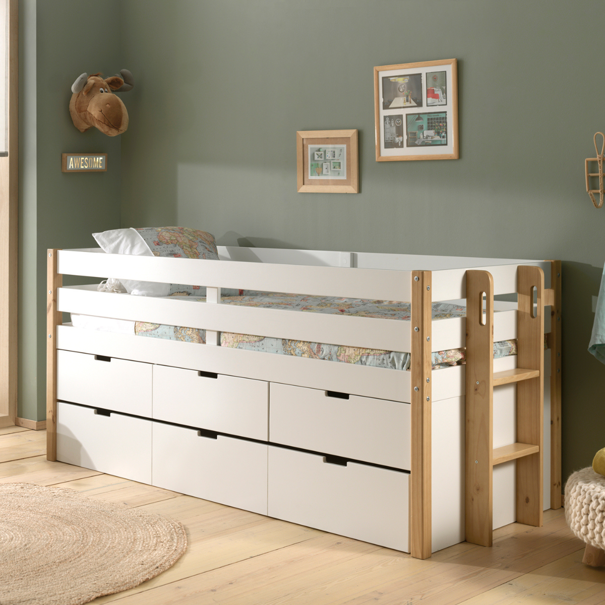 White and wooden kids mid sleeper cabin bed with multiple underbed storage drawers in a room with green walls and framed picture