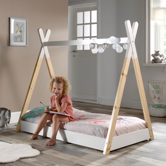 Child sitting on a VIPACK Sheila teepee-style floor bed in a bright room with natural light.