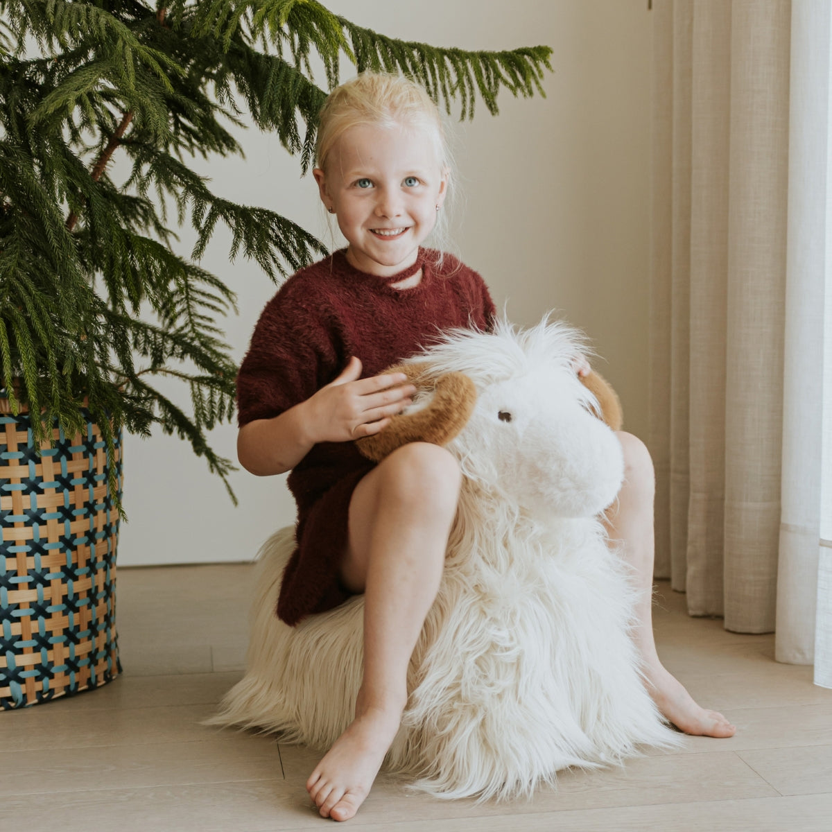 a yound child sitting on a soft wild and soft bouncy ram in living room