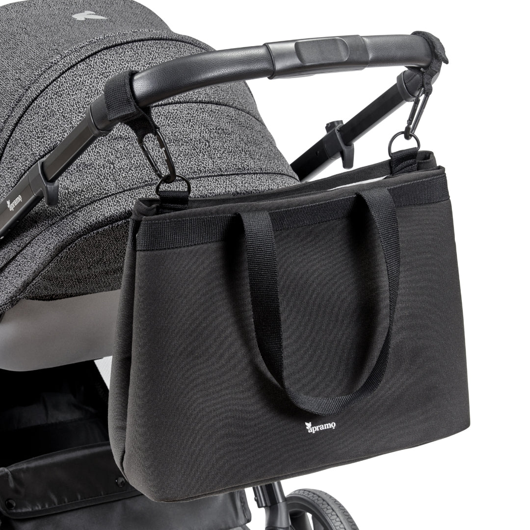 black baby changing tote bag attached to pushchair using stroller hooks