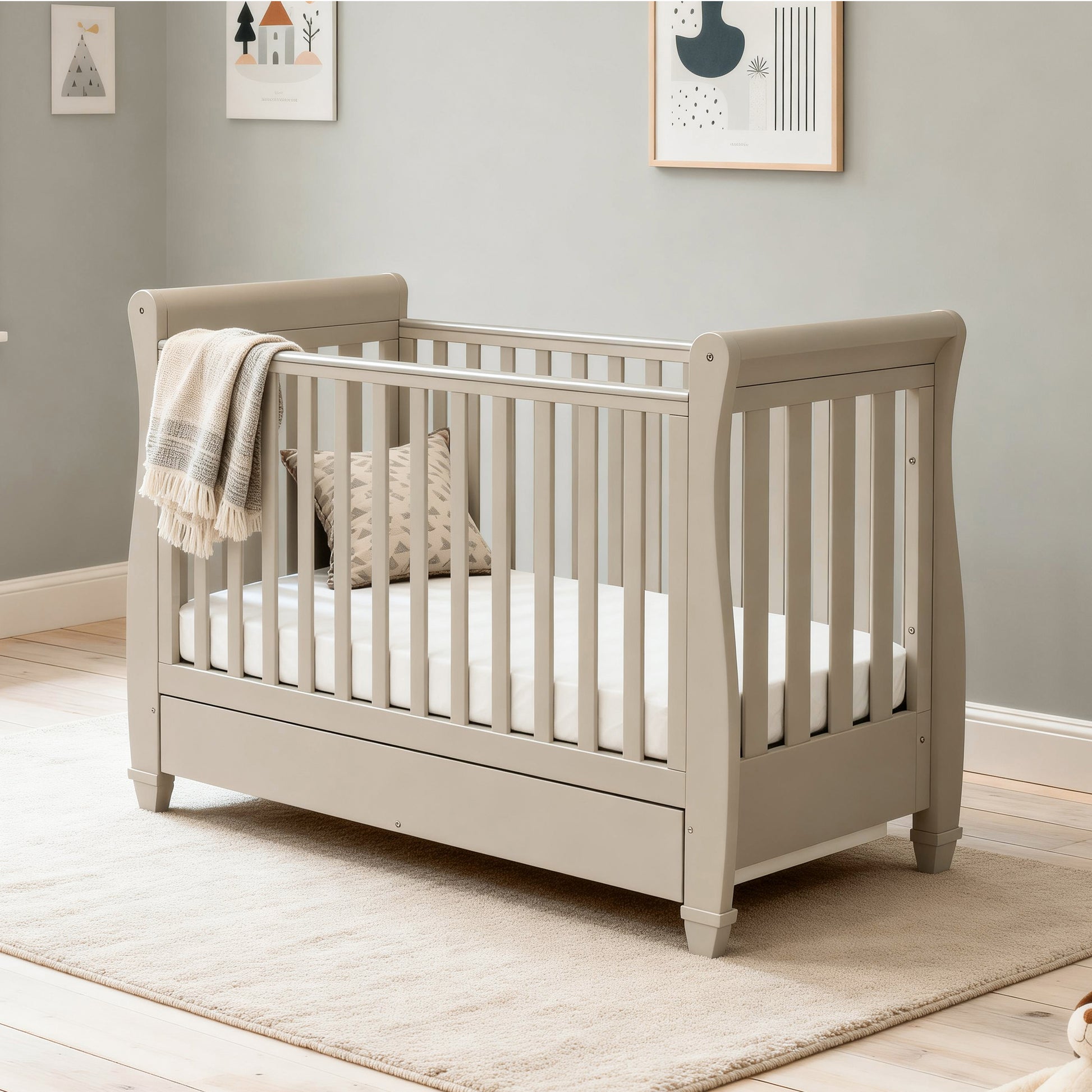 Babymore Eva sleigh cot bed cashmere with mattress and blanket hanging over side in modern nursery