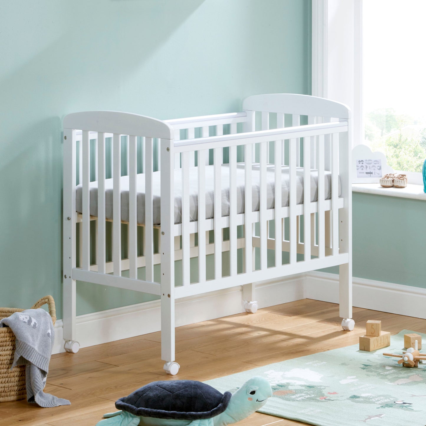 Babymore Space Saver Cot in White with lockable wheels and adjustable base in small  baby nurseryK