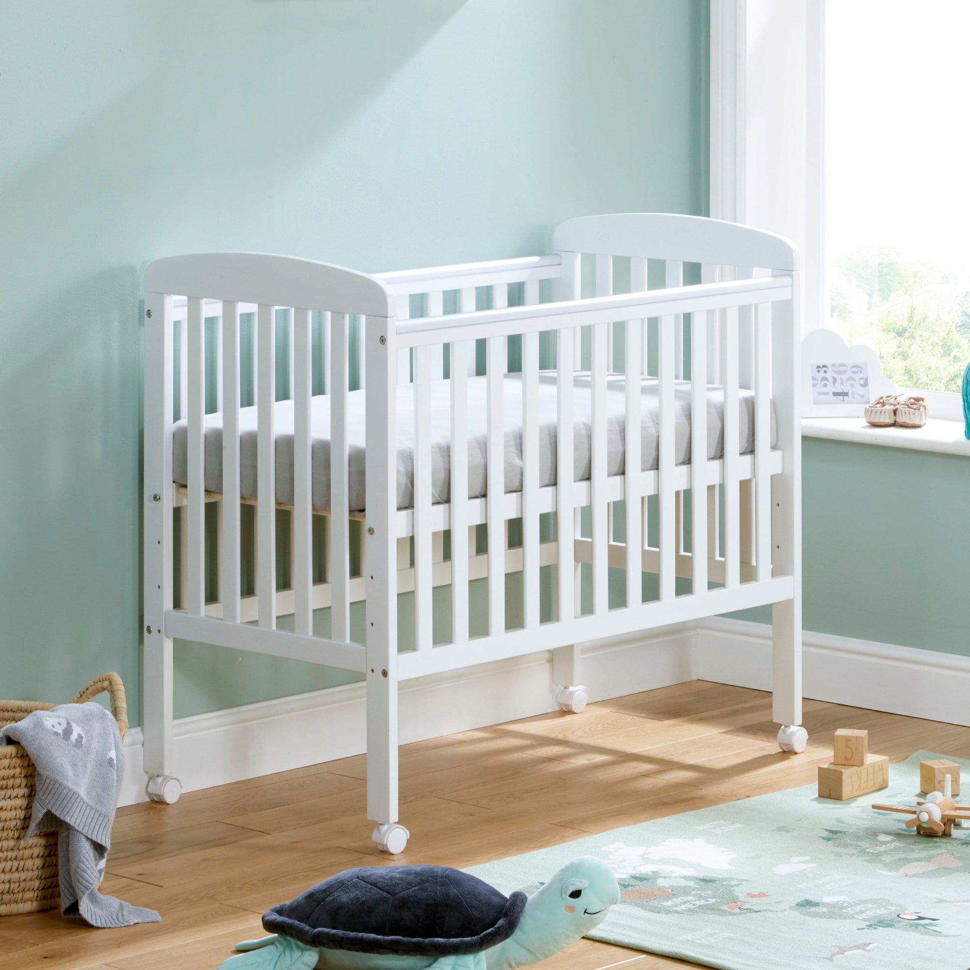 Babymore Space Saver Cot in White with lockable wheels and adjustable base in small  baby nurseryK