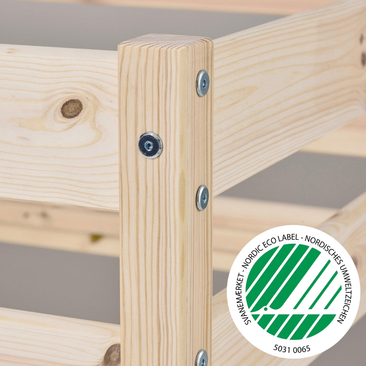 close up view of Hoppekids Eco comfort mid sleeper natural pine wood showing wood grain and solid allen key bolt fittings and nordic eco label