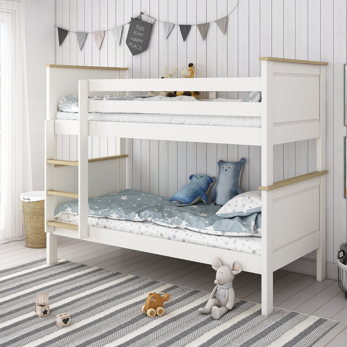 White children's detachable bunk bed with wooden accents in a room with a striped rug and toys.