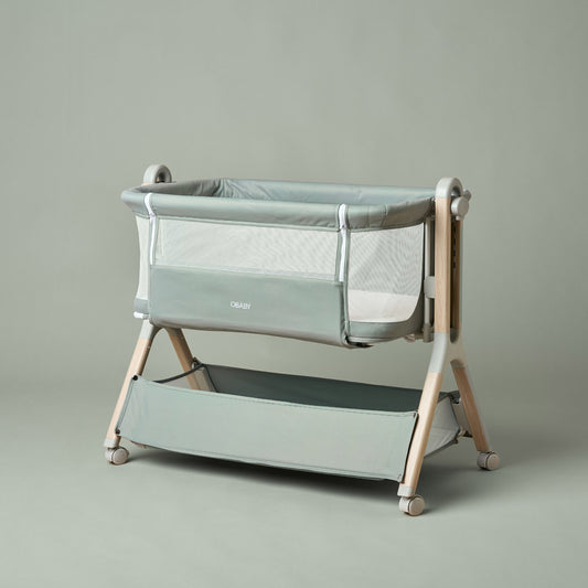 Obaby Cloud next to me bedside crib in Sage green with mesh side panels and included 79 × 48cm mattress