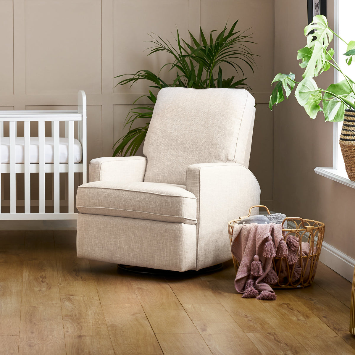 Obaby Madison swivel glider recliner nursing chair in oatmeal upholstery with padded seat and backrest in baby nursery