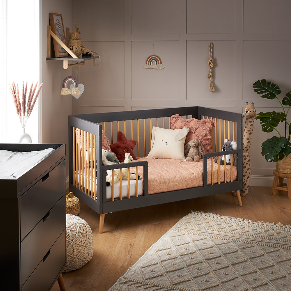 Obaby Maya Cot Bed in Slate and Natural converted into toddler bed with safety bed guards in nursery with modern decor