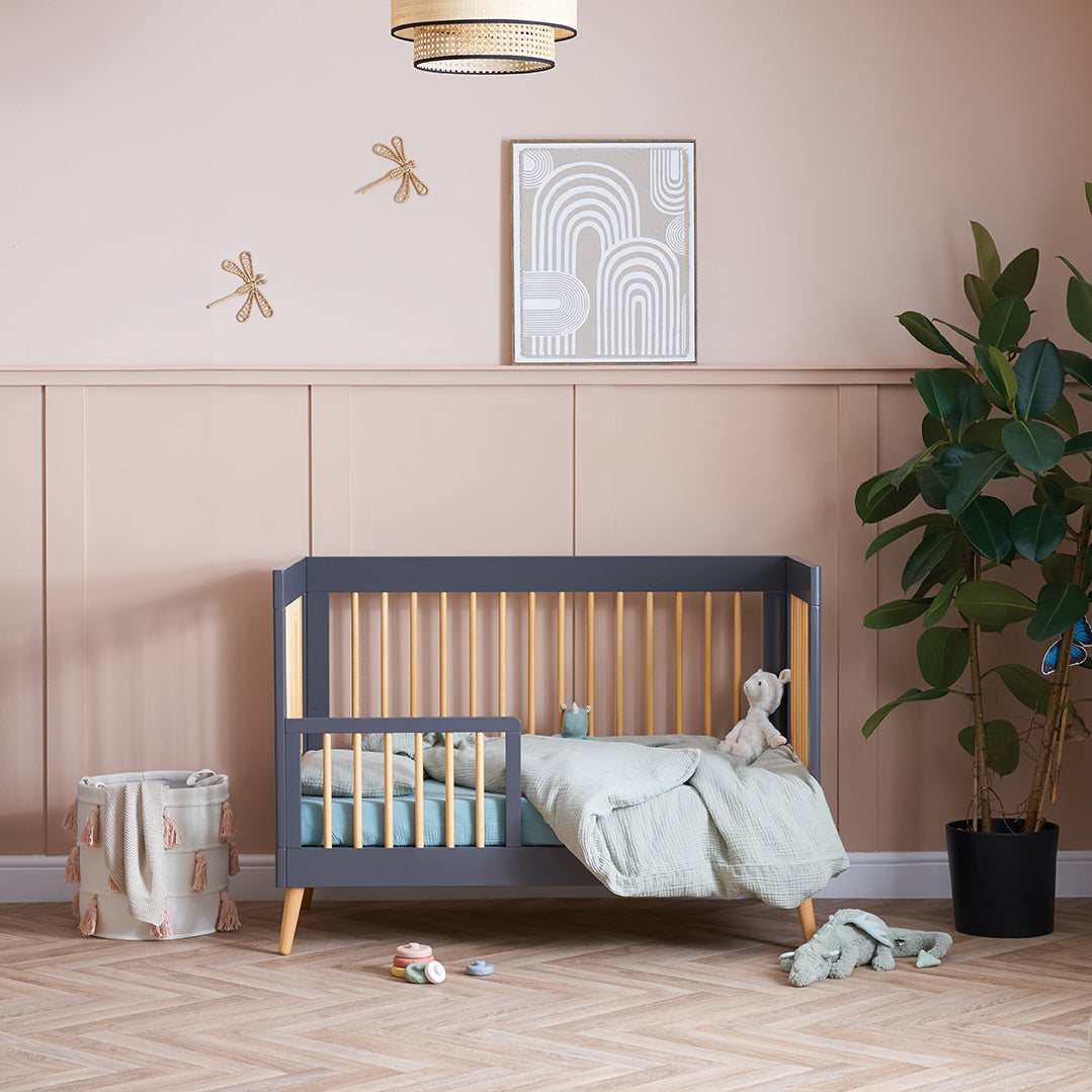 Obaby Maya Mini Cot Bed in Slate converted into toddler bed with bed guard in nursery bedroom