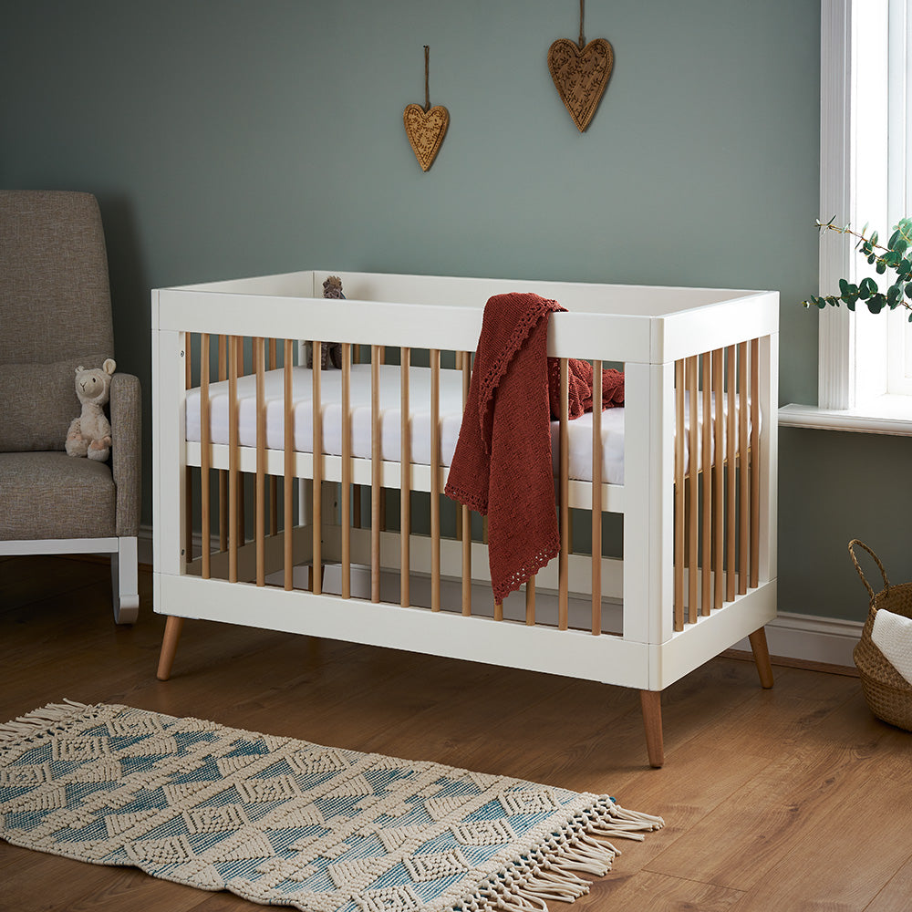 Obaby Maya Mini Cot Bed in White and Natural with Scandinavian-inspired styling for a 120 × 60cm mattress in bbay nursery