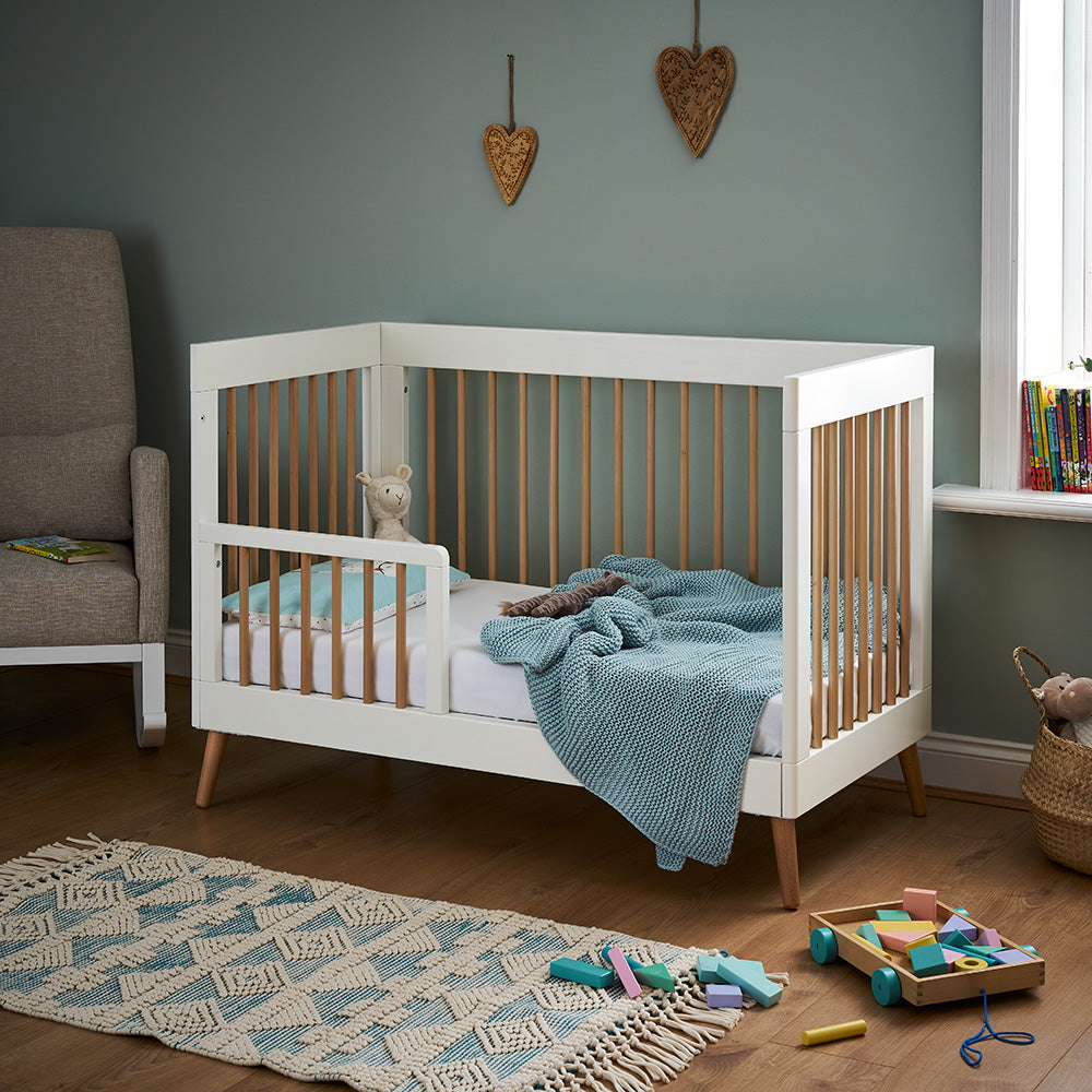 Obaby Maya Mini Cot Bed in White and Natural with toddler bed guard in modern nursery