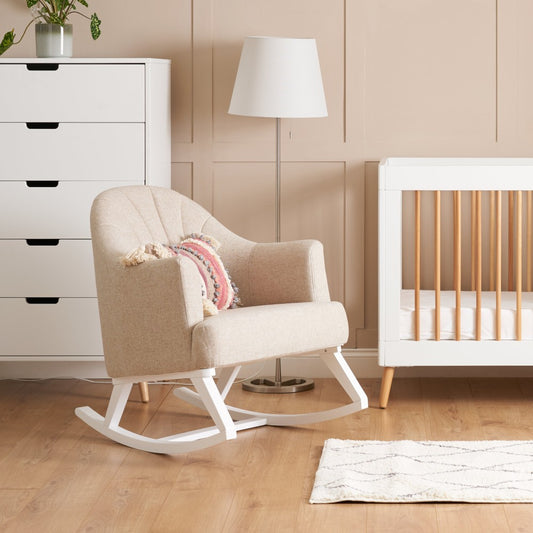 Obaby Round Back nursing rocking chair Oatmeal next to white cot bed in baby nursery