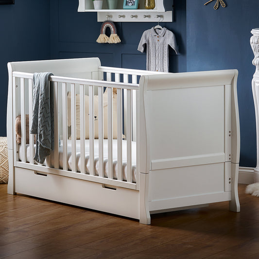 Obaby Stamford Classic sleigh cot bed in white with curved ends and matching under drawer in baby nursery
