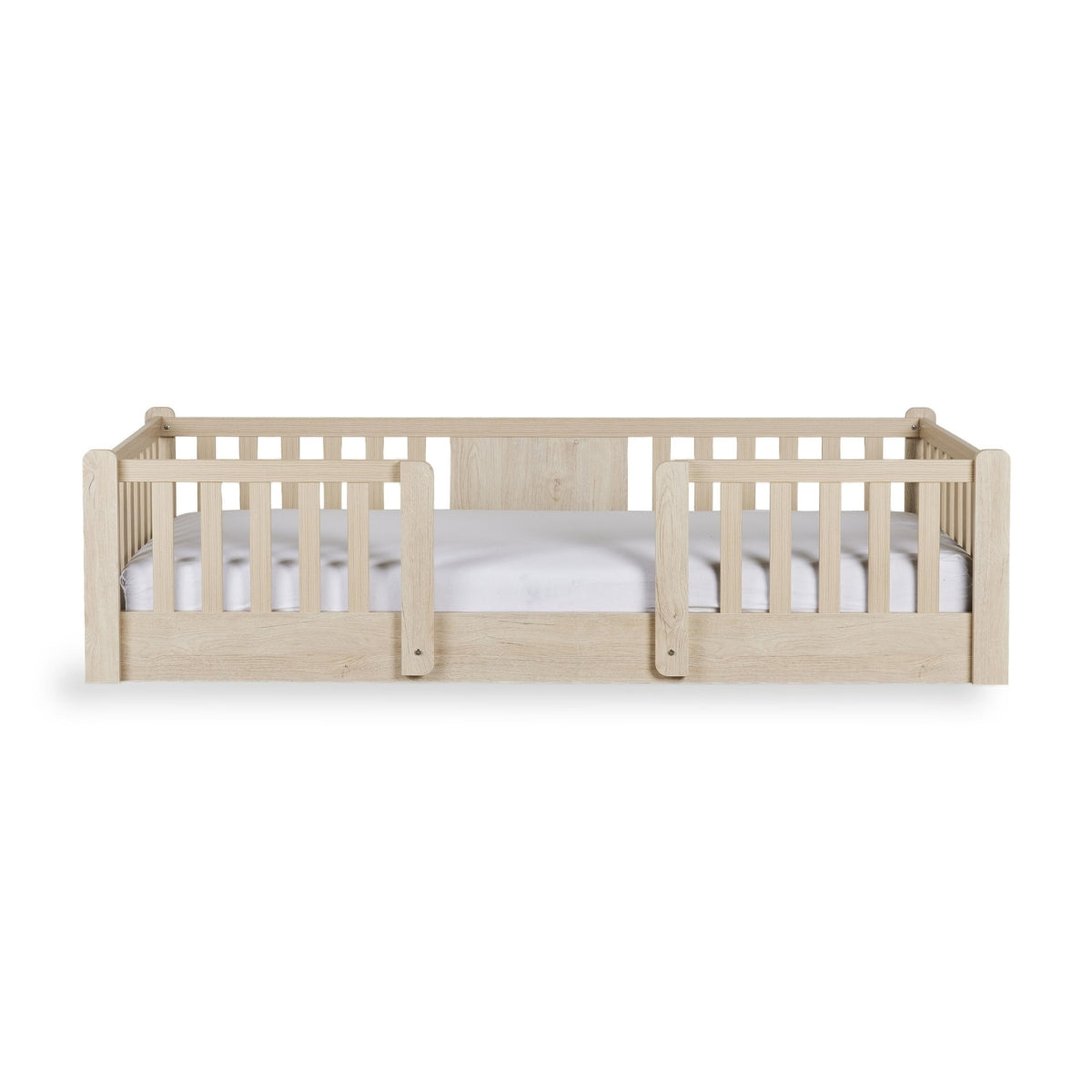 A light natural wood toddler floor bed with integrated guard rails and a white mattress, shown against a plain white background.