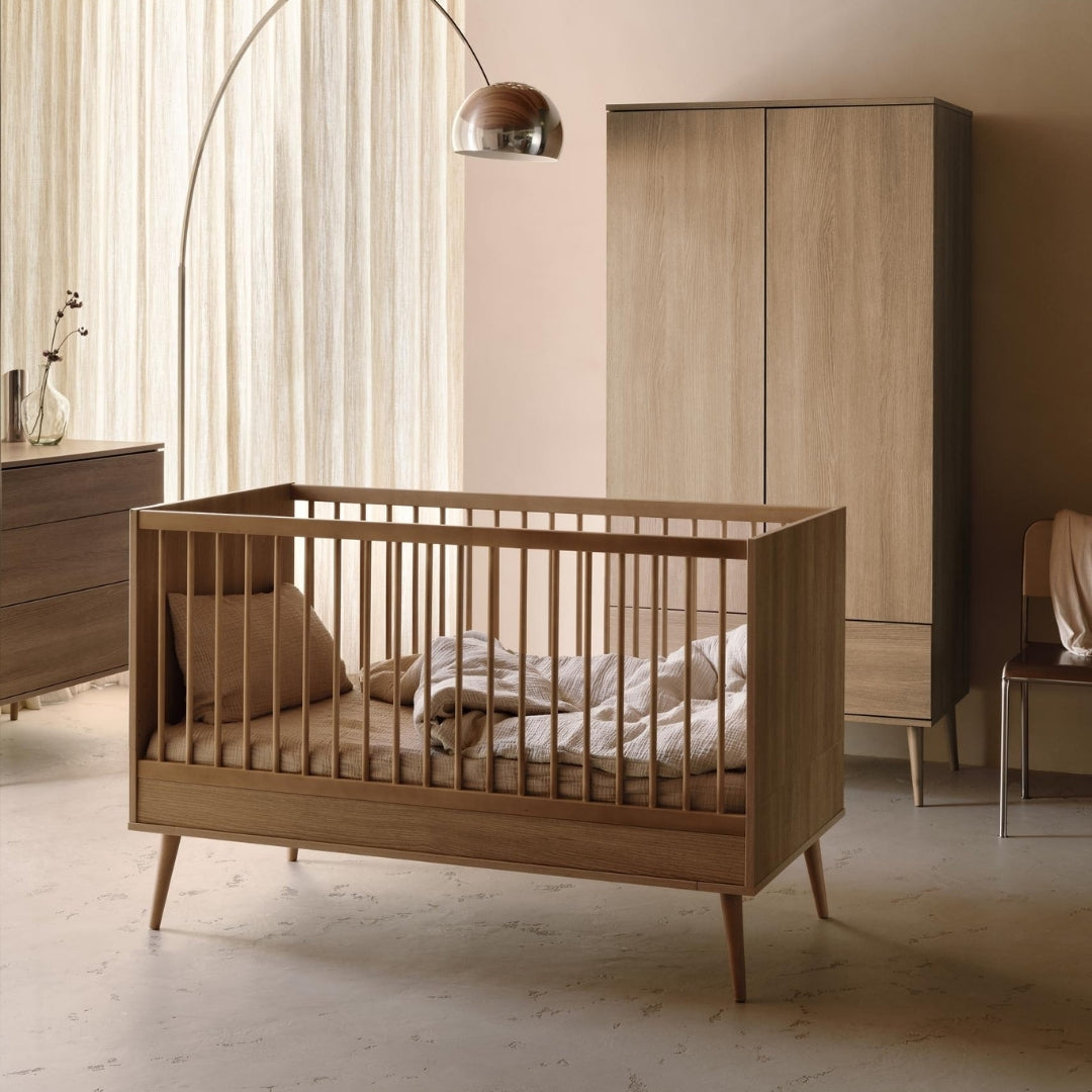 Scandinavian style wooden baby cot bed 140x70 with mid-century legs in modern neutral nursery