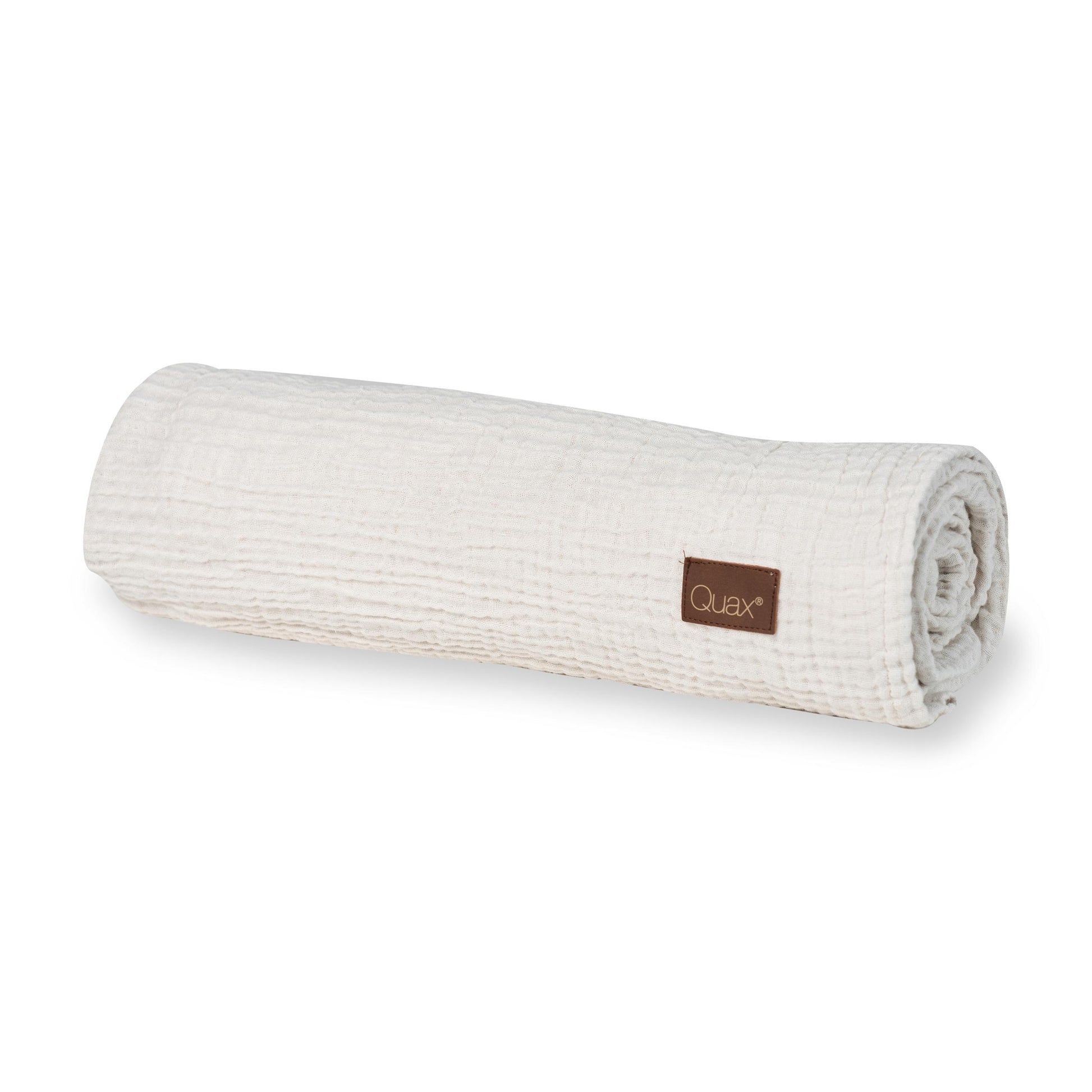 Rolled-up clay Quax 100% cotton muslin baby blanket on a plain white background