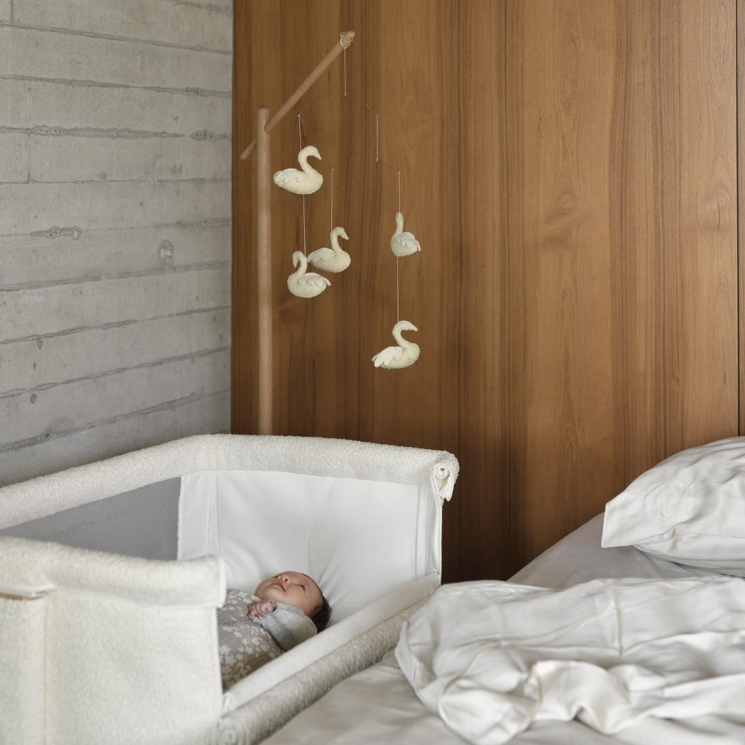 quax swans baby mobile hanging from wooden stand over next to me co sleeper crib 