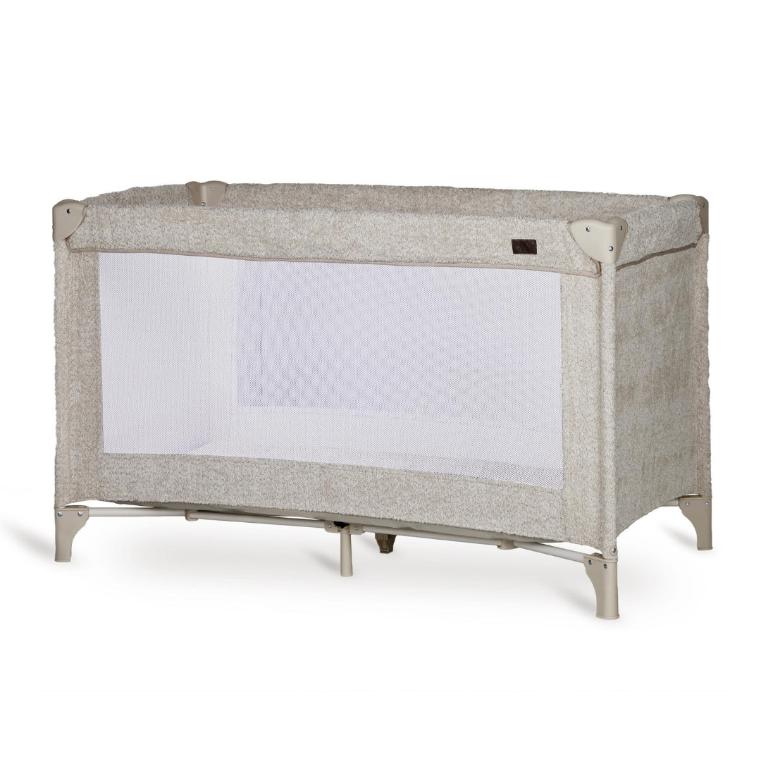 Quax travel cot with soft sheep boucle fabric on plain white background