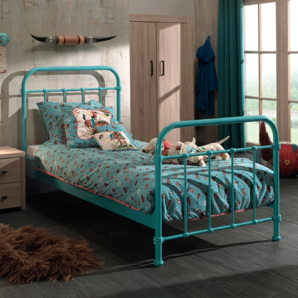Teal metal single bed with bedding and pillows in a bedroom setting.
