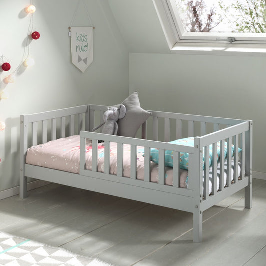 grey wooden toddler bed with pink bedding in nursery bedroom