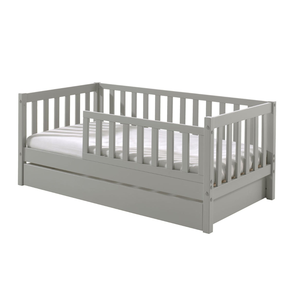 grey toddler bed with underbed storage drawer in white mattress on plain white background